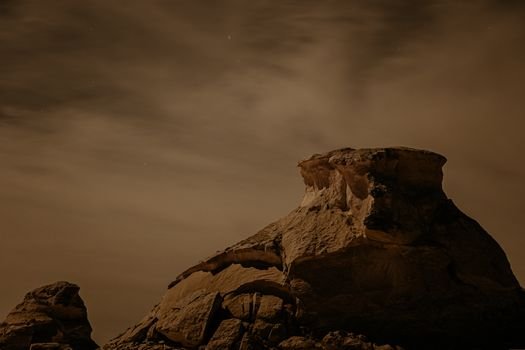 Captivating night view of rock formation in Siwa Oasis, Egypt under a starry sky.