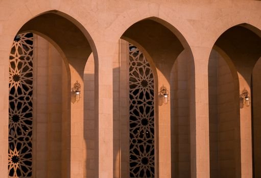Beautiful arches with intricate designs and lamps in a Bahrain building.