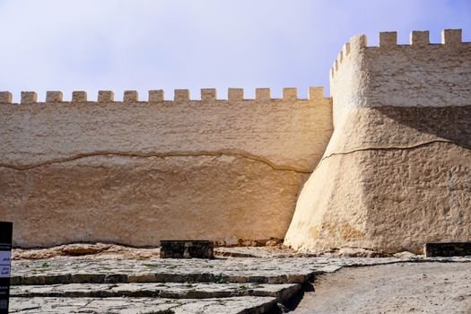A well-lit view of a historic fort wall showcasing ancient architecture with a rugged stone pathway.