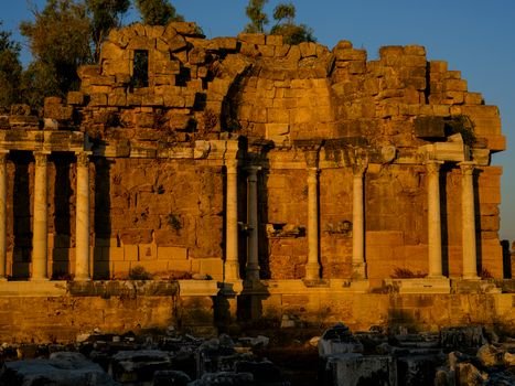 A stunning view of ancient Roman ruins bathed in warm evening sunlight.