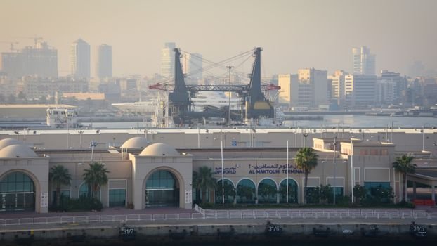 View of Al Maktoum Terminal with cranes and Dubai skyline in the background.