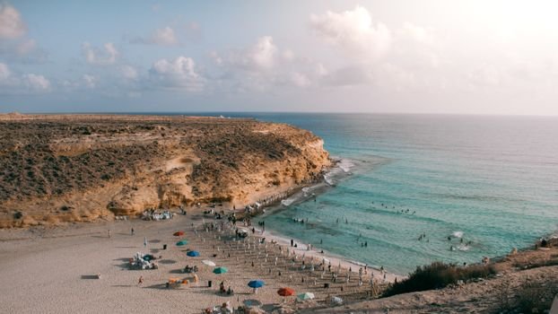 Panoramic summer view of Marsa Matruh beach with cliffs and turquoise water.