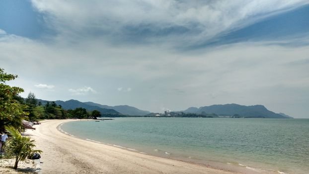 Tranquil beach scene at Langkawi, featuring sandy shores and clear waters under a sunny sky.