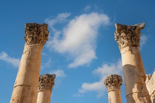 Explore the historic Roman columns of Jerash, Jordan beneath a clear blue sky.