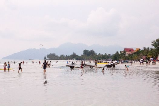 Vibrant beach day in Langkawi with people enjoying summer activities.