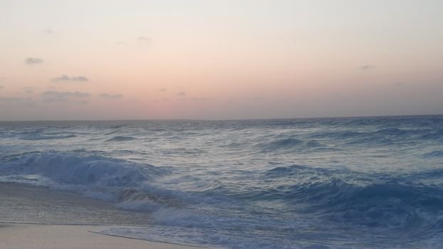 Gentle ocean waves under a calming sunset sky, perfect for relaxation themes.