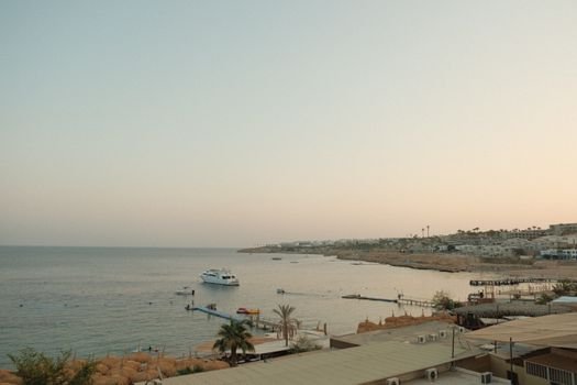 A tranquil sunset view of the Sharm El Sheikh coastline with a boat and tranquil waters.