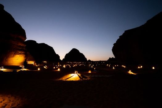 Experience the magical desert landscape of AlUla at dusk, beautifully lit by lanterns.