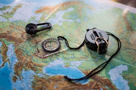 Flat lay of a European map with two compasses, symbolizing travel and exploration.