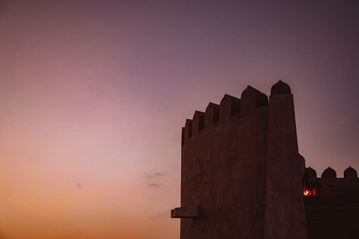 Silhouette of a fort wall against a colorful twilight sky, capturing the evening essence.