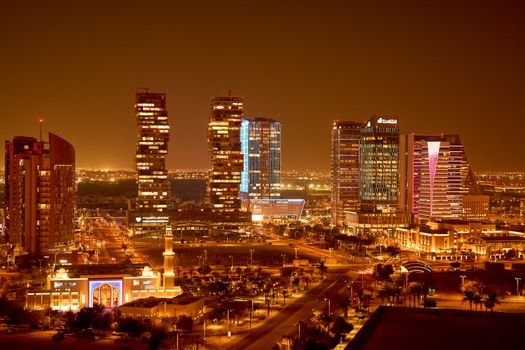 Vibrant city skyline captured at night, showcasing beautifully lit modern architecture.