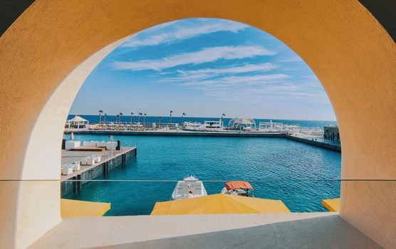 Beautiful view of Hurghada marina from an archway, capturing the tranquil blue sea and clear sky.