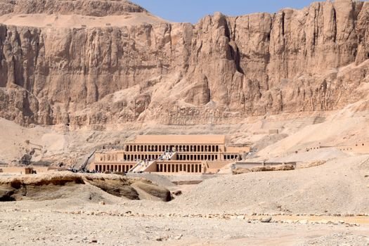 The ancient Hatshepsut Temple in Luxor set against the dramatic cliffs under a clear blue sky.