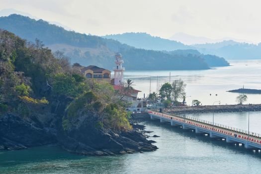 Serene view of Langkawi's coastline featuring a lighthouse and scenic landscape.