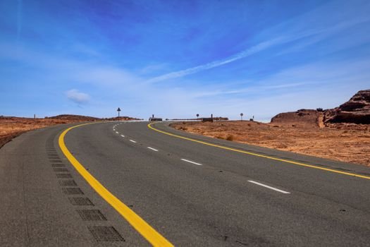 Scenic curved road cutting through the desert landscape in Tayma, Saudi Arabia.