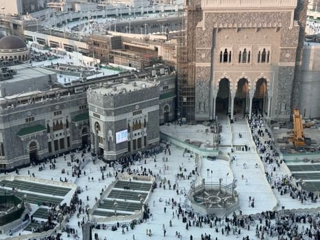 High-angle view of Masjid al-Haram in Mecca, Saudi Arabia, showcasing the grand architecture and bustling courtyard.
