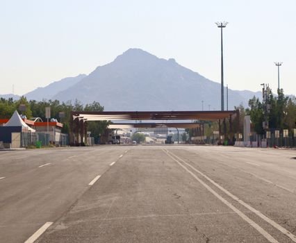 Empty highway with a scenic mountain view in the background, clear sky, daytime.